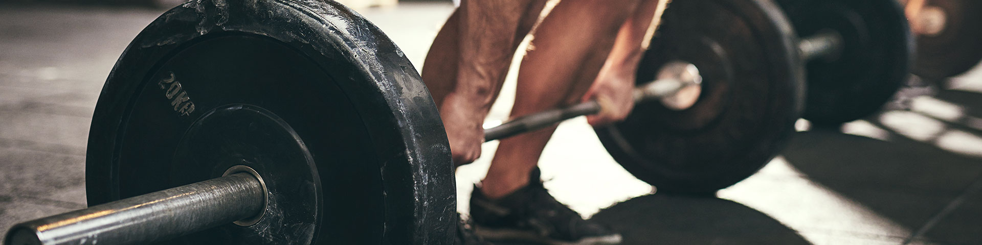 Mann hebt Gewwicht mit Langhantel